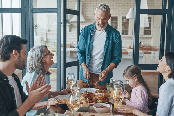 Feliz familia multi-generación comunicándose y sonriendo mientras cenan juntos —  Fotos de Stock