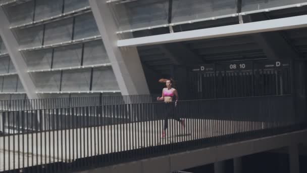 Pleine longueur de belle jeune femme en vêtements de sport courant à l'extérieur — Video