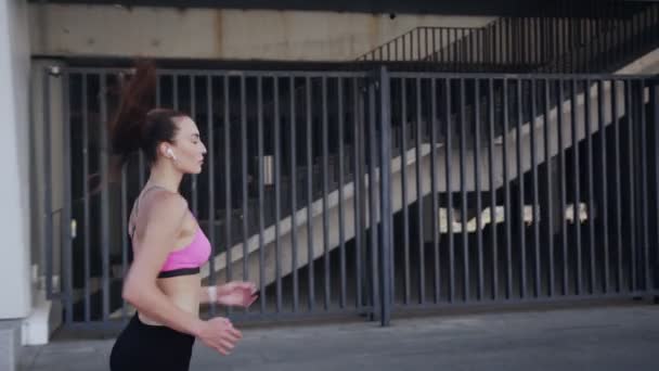 Mujer joven y segura en ropa deportiva corriendo al aire libre — Vídeos de Stock