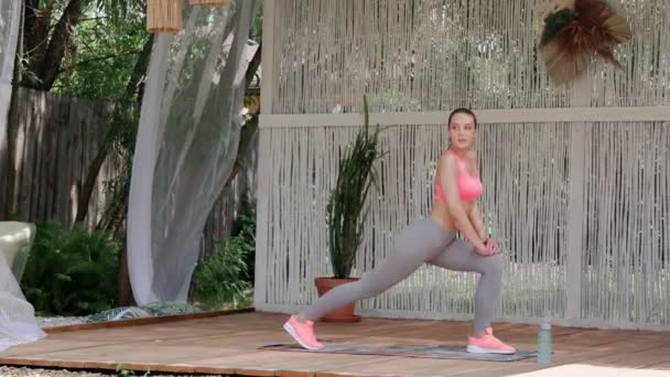Longitud completa de la mujer joven en ropa deportiva haciendo ejercicios de estiramiento — Vídeos de Stock