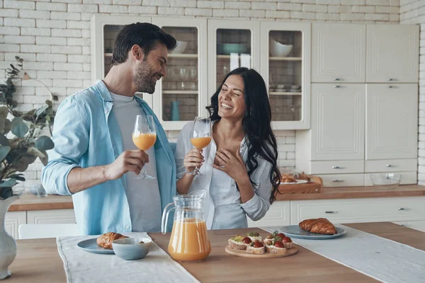 Hermosa pareja joven preparando el desayuno juntos mientras pasan tiempo en la cocina doméstica —  Fotos de Stock