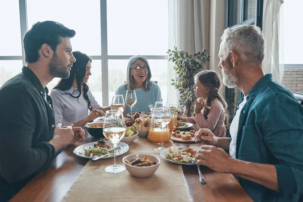 Sorrindo família de várias gerações comunicando enquanto jantamos juntos — Fotografia de Stock