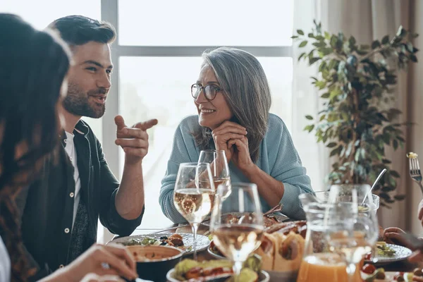 Feliz família multi-geração comunicando e sorrindo enquanto jantamos juntos — Fotografia de Stock