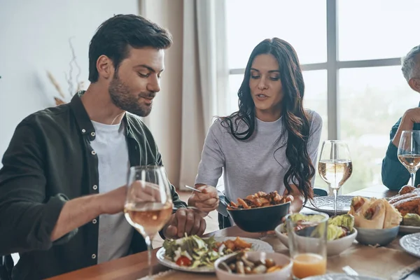 Moderne Familie kommuniziert und lächelt beim gemeinsamen Abendessen — Stockfoto