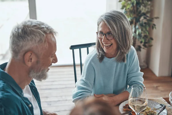 Glad senior par kommunicera och leende medan du äter middag tillsammans — Stockfoto