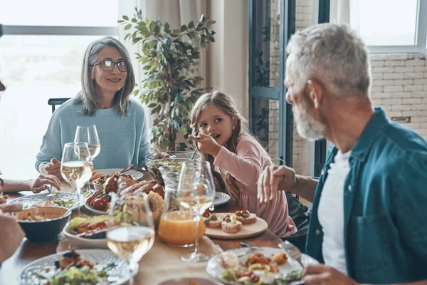 Hermosa familia multi-generación comunicándose y sonriendo mientras cenan juntos —  Fotos de Stock