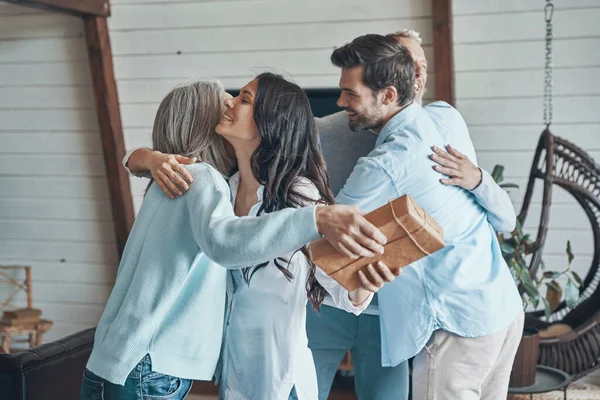 Cheerful senior parents meeting young couple inside the house — Stock Photo, Image