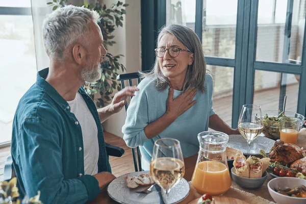 Happy senior couple communicating and smiling while having dinner together — Stock Photo, Image