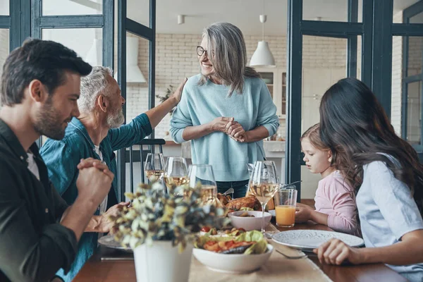 Modern nesil aile yemeği yerken iletişim kuruyor ve gülümsüyor. — Stok fotoğraf