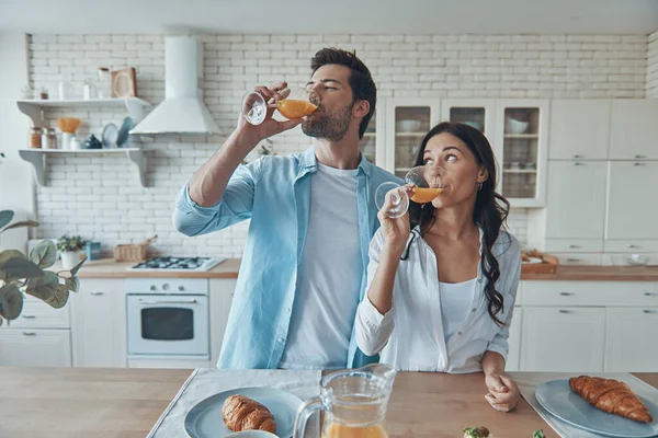 Vackra unga par njuter av frukost tillsammans medan spendera tid i det inhemska köket — Stockfoto