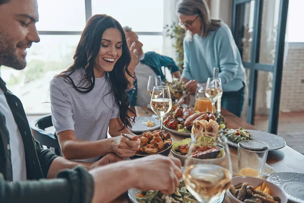 Glad flergenerationsfamilj som kommunicerar och ler samtidigt som de äter middag tillsammans — Stockfoto