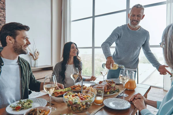 Famiglia felice multi-generazione che comunica e sorride cenando insieme — Foto Stock