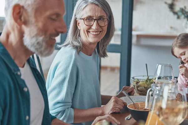 Glückliches Seniorenpaar kommuniziert und lächelt beim gemeinsamen Abendessen — Stockfoto