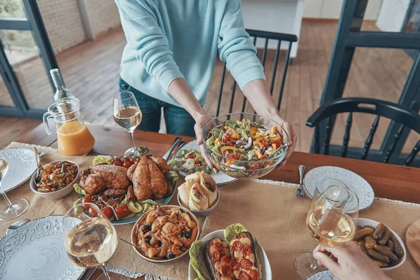 Nahaufnahme einer Frau, die während eines Familientreffens Essen auf dem Tisch serviert — Stockfoto