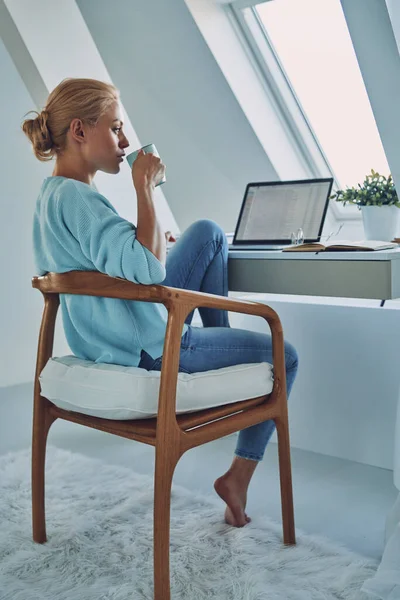 Hermosa joven bebiendo café mientras trabaja en casa —  Fotos de Stock