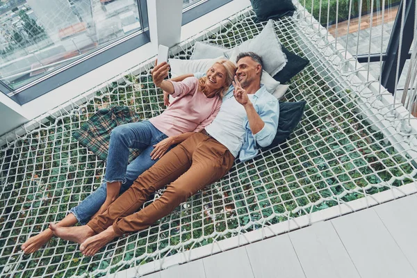 Top view of beautiful mature couple making selfie by smart phone and smiling — Stock Photo, Image