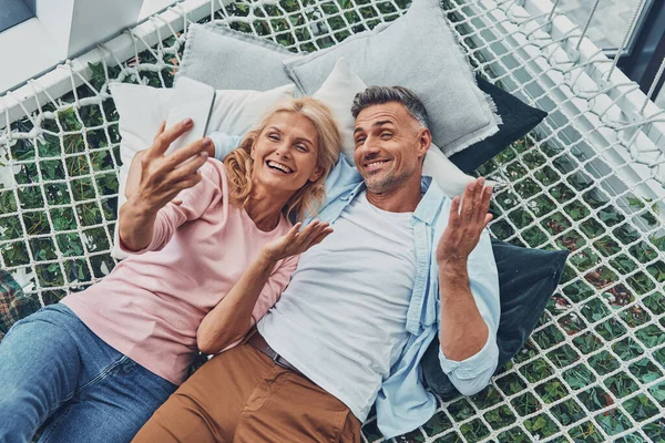 Top view of beautiful mature couple making selfie by smart phone and smiling — Stock Photo, Image