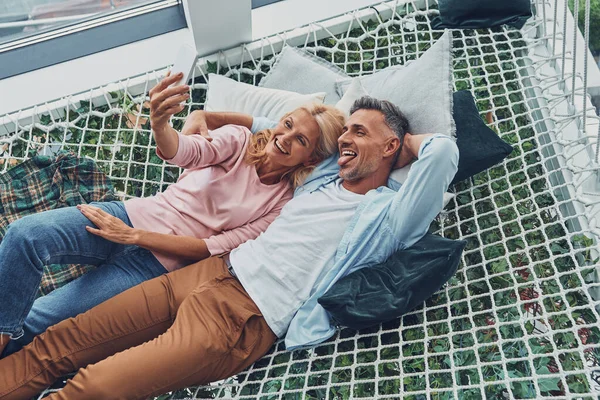 Top view of beautiful mature couple making selfie by smart phone and smiling — Stock Photo, Image