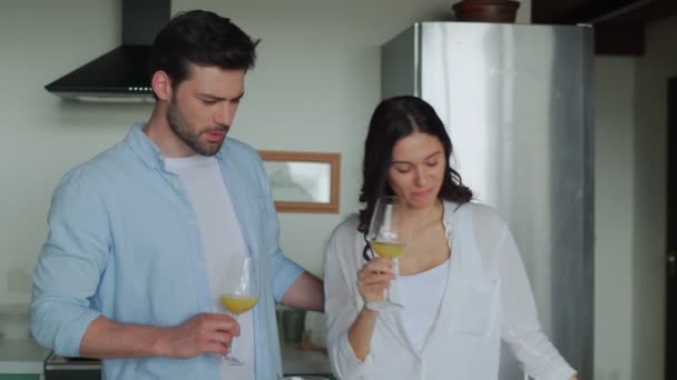 Boldog fiatal pár narancslevet iszik, miközben a konyhában vannak. — Stock videók