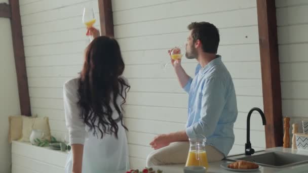 Красива молода пара посміхається і танцює, проводячи час на кухні — стокове відео