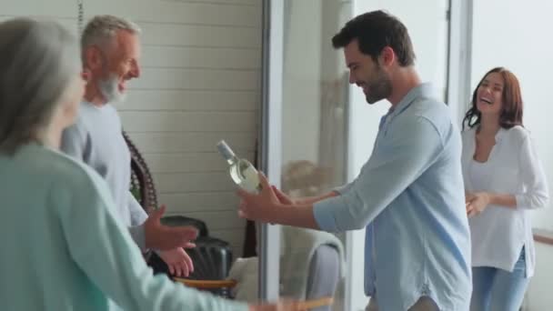 Seitenansicht glücklicher Senioren, die ein junges Paar im Haus treffen — Stockvideo