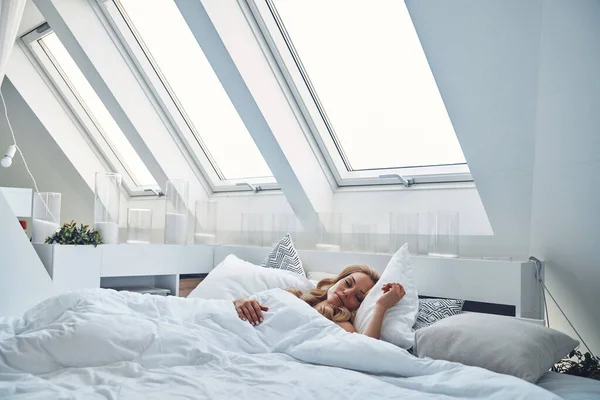 Hermosa mujer de pelo rubio joven durmiendo en la cama y cubierto con manta — Foto de Stock