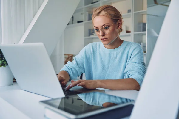 Gyönyörű fiatal nő használja laptop, miközben dolgozik az irodában — Stock Fotó