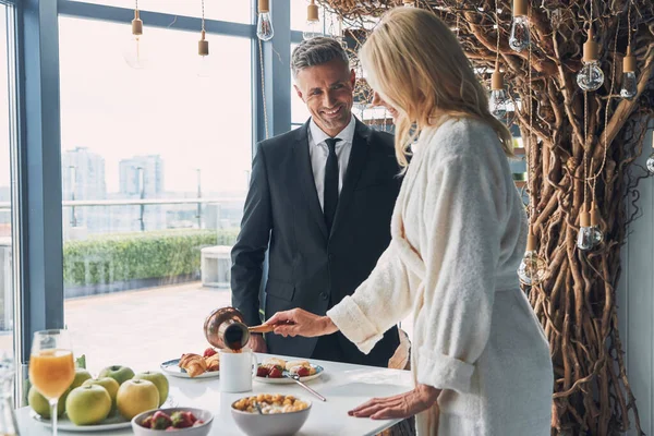 Mooi volwassen paar genieten van het ontbijt samen terwijl het doorbrengen van tijd in de binnenlandse keuken — Stockfoto