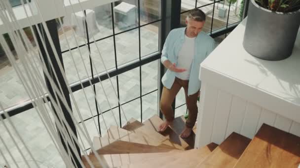 Beau couple d'âge mûr examinant la nouvelle maison tout en montant les escaliers ensemble — Video