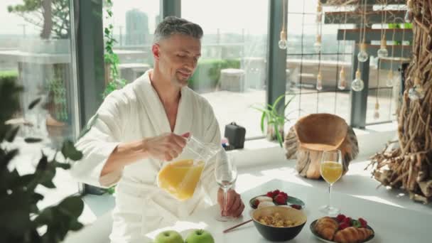 Volwassen paar genieten van het ontbijt samen terwijl het doorbrengen van tijd in de keuken — Stockvideo