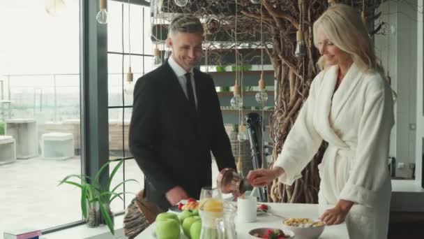 Idős pár együtt reggelizik, miközben a konyhában töltik az idejüket. — Stock videók