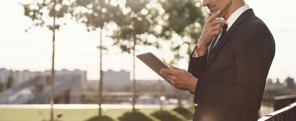 Ragionevole uomo d'affari maturo che lavora su tablet digitale mentre si trova all'aperto — Foto Stock