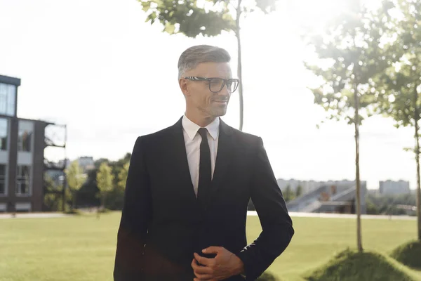 Selbstbewusster reifer Geschäftsmann mit Brille, der im Freien wegschaut — Stockfoto