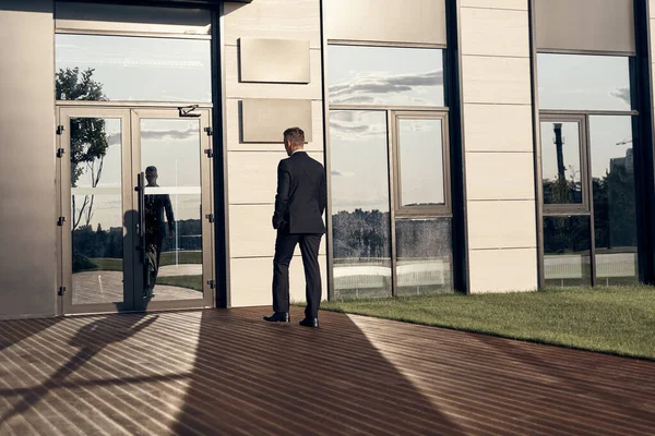 Rear view of businessman walking near office building outdoors — Stock Photo, Image