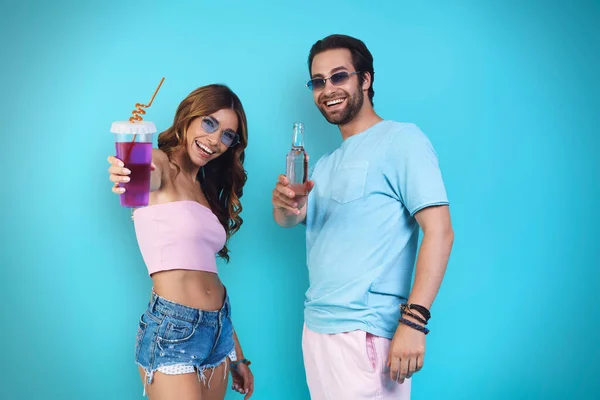 Beautiful Young Smiling Couple Enjoying Drinks Smiling While Standing Blue — Stock Photo, Image