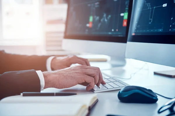 Gros plan de l'homme tapant quelque chose en utilisant l'ordinateur tout en travaillant dans le bureau — Photo