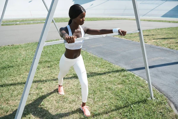 Belle jeune femme africaine en vêtements de sport s'étendant à l'extérieur — Photo