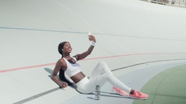 Spor elbiseli güzel Afrikalı bir kadın video çekiyor. 