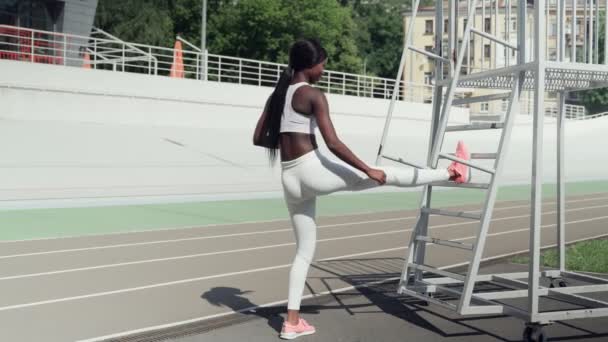 Selbstbewusste junge Afrikanerin in Sportkleidung macht Dehnübungen — Stockvideo