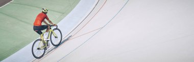 Spor elbiseli bir adamın açık havada bisiklet sürüşünün en iyi görüntüsü.
