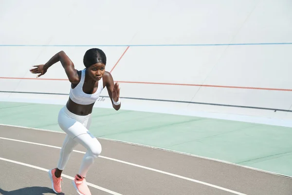 Hermosa joven africana en ropa deportiva corriendo en pista al aire libre —  Fotos de Stock