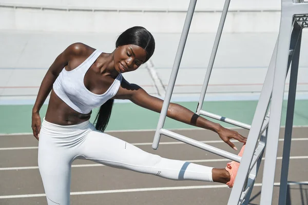 Sebevědomý mladý afričan žena ve sportovním oblečení dělat strečink cvičení venku — Stock fotografie