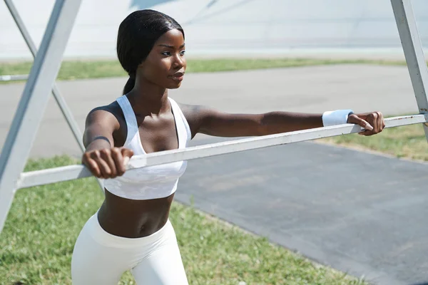 Hermosa joven africana en ropa deportiva relajante después de entrenar al aire libre — Foto de Stock