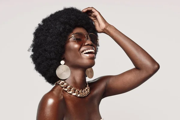 Belle jeune femme africaine en bijoux dorés gardant les yeux fermés et souriants — Photo