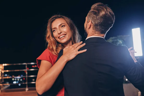 Красивая молодая пара в формальной одежде танцует и улыбается — стоковое фото