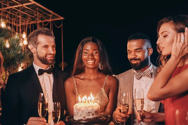 Gruppo di persone in abbigliamento formale che tengono la torta di compleanno mentre trascorrono del tempo alla festa — Foto Stock