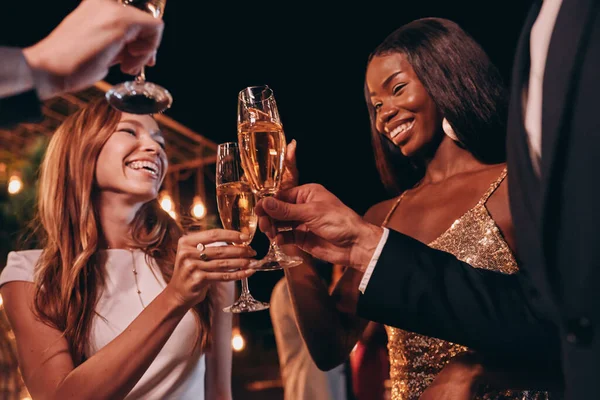 Grupp människor i formella kläder skålar med champagne och leende samtidigt spendera tid på lyx fest — Stockfoto