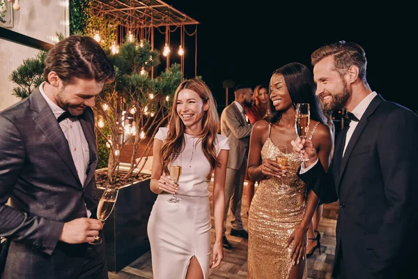 Gruppe von schönen Menschen in Formalbekleidung kommunizieren und lächeln, während sie Zeit auf einer Luxusparty verbringen — Stockfoto