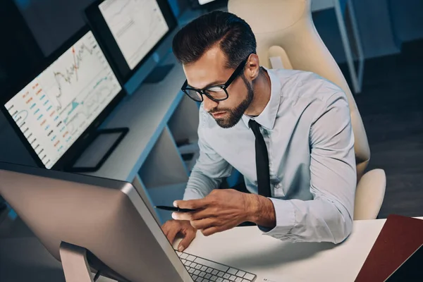 Visão superior do jovem confiante em camisa e gravata usando o telefone enquanto permanece até tarde no escritório — Fotografia de Stock