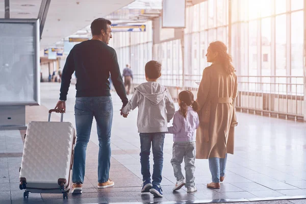 Pełna długość widok z tyłu rodziny z dwójką małych dzieci spacerujących przez terminal lotniska — Zdjęcie stockowe